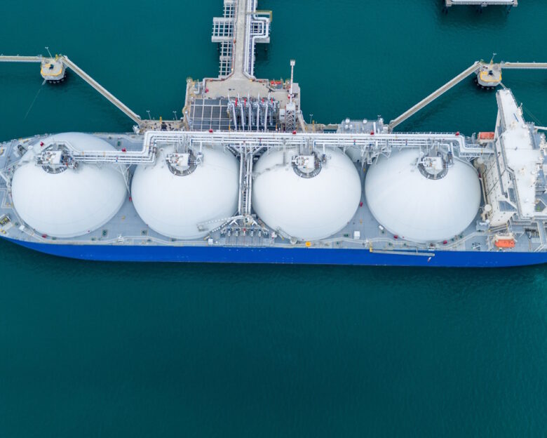 LNG (Liquefied natural gas) tanker anchored in Gas terminal gas tanks for storage. Oil Crude Gas Tanker Ship. LPG at Tanker Bay Petroleum Chemical or Methane freighter export import transportation