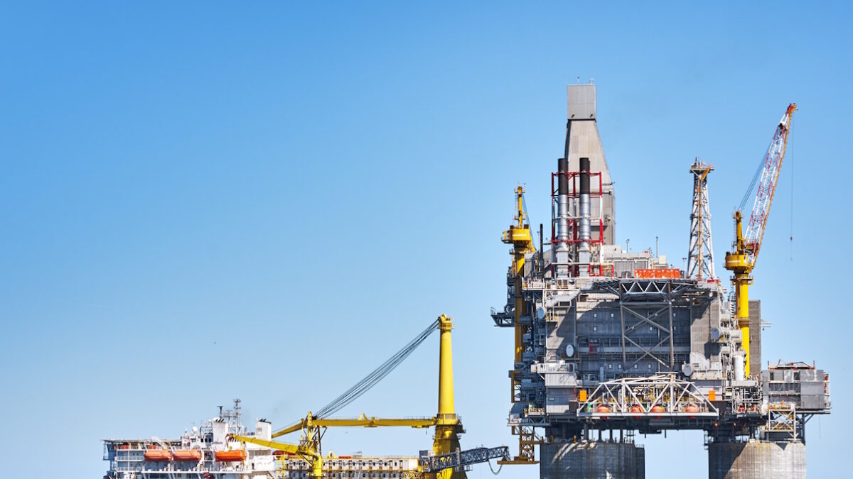 Oil rig and support vessel on offshore area near Sakhalin island. Blue sky background