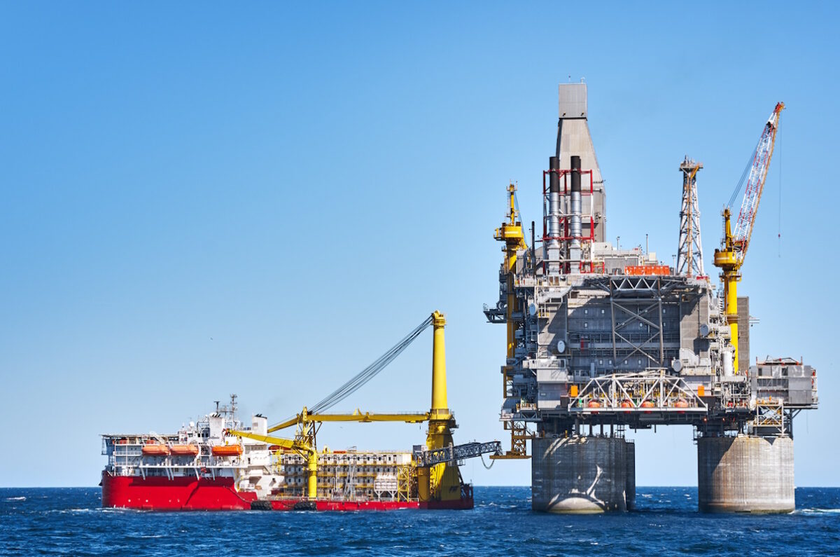 Oil rig and support vessel on offshore area near Sakhalin island. Blue sky background