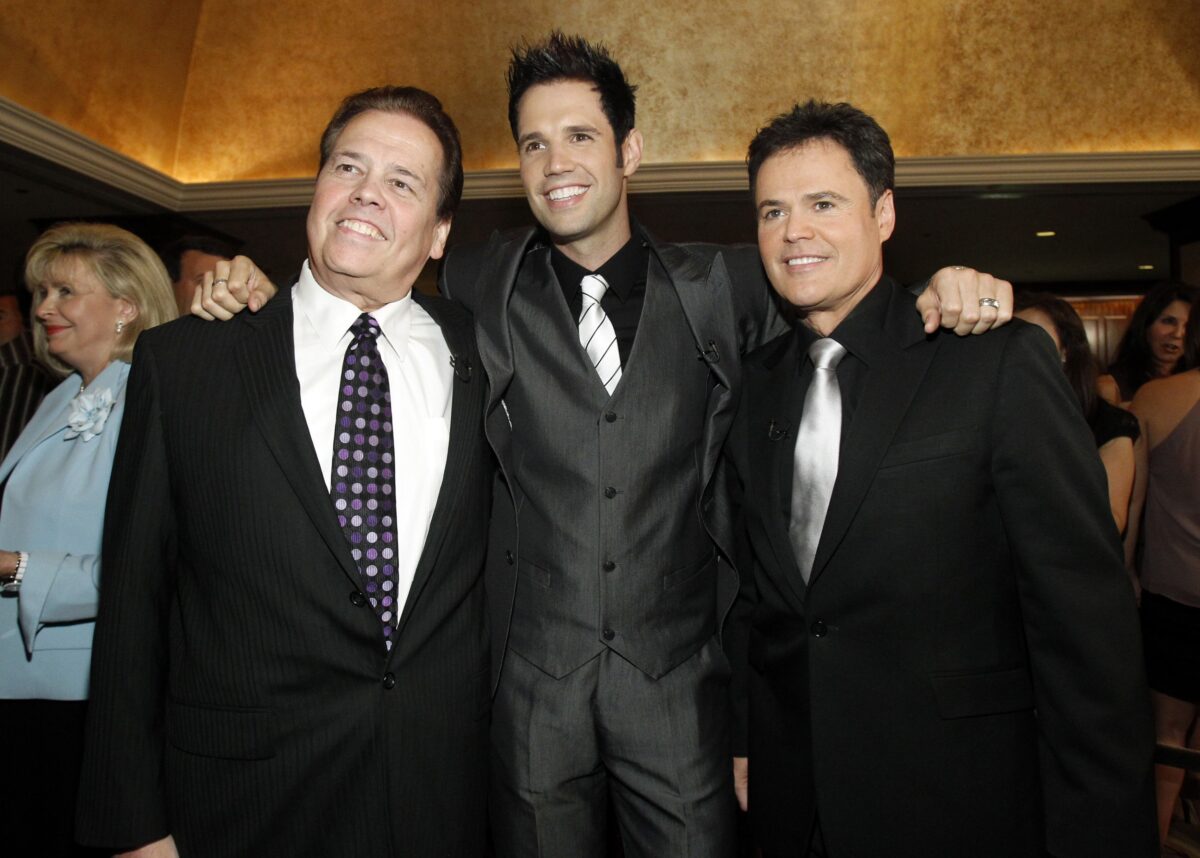 Actor Donny Osmond (R) poses with his brothers Alan (L) and David