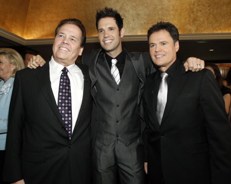 Actor Donny Osmond (R) poses with his brothers Alan (L) and David