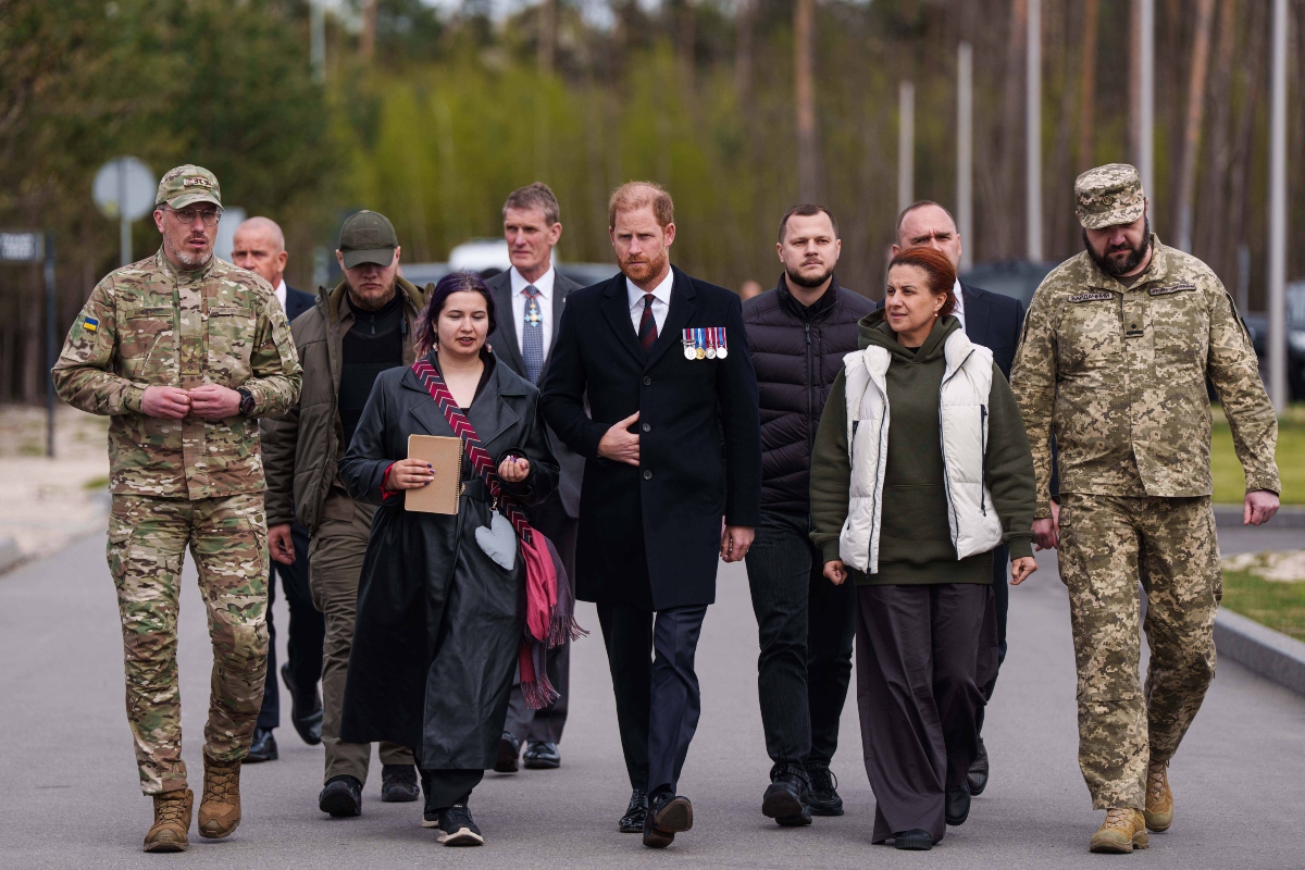 Britain's Prince Harry, center, and Ukraine Veteran's Minister Natalia Kalmykova, right, walk at a military cemetery near Kyiv, Ukraine, on Friday, April 24, 2026.