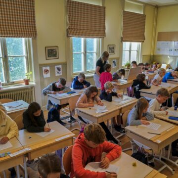 A teacher helps students practice their handwriting at the Djurgardsskolan elementary school in Stockholm, Sweden, Thursday, Aug. 31, 2023. As children across Sweden have recently flocked back to school after the summer vacation, many of their teachers are putting a new emphasis on printed books, quiet reading hours, and practicing handwriting as the country's yearslong focus on the digitalization of classrooms has come under scrutiny.