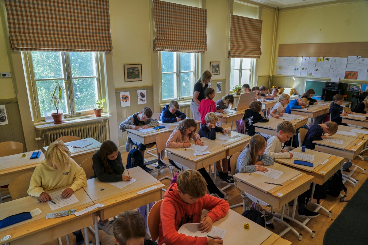 A teacher helps students practice their handwriting at the Djurgardsskolan elementary school in Stockholm, Sweden, Thursday, Aug. 31, 2023. As children across Sweden have recently flocked back to school after the summer vacation, many of their teachers are putting a new emphasis on printed books, quiet reading hours, and practicing handwriting as the country's yearslong focus on the digitalization of classrooms has come under scrutiny.
