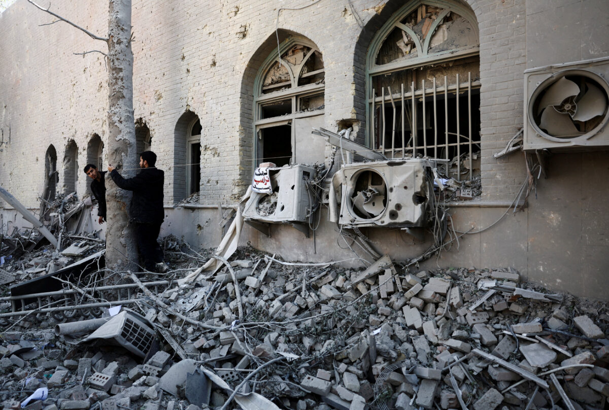 People stand amidst the rubble of a building of the Sharif University of Technology, which was damaged in a strike, amid the U.S.-Israeli conflict with Iran, in Tehran, Iran, April 7, 2026. Majid Asgaripour