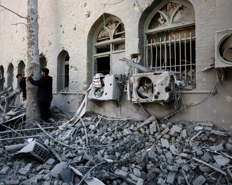 People stand amidst the rubble of a building of the Sharif University of Technology, which was damaged in a strike, amid the U.S.-Israeli conflict with Iran, in Tehran, Iran, April 7, 2026. Majid Asgaripour