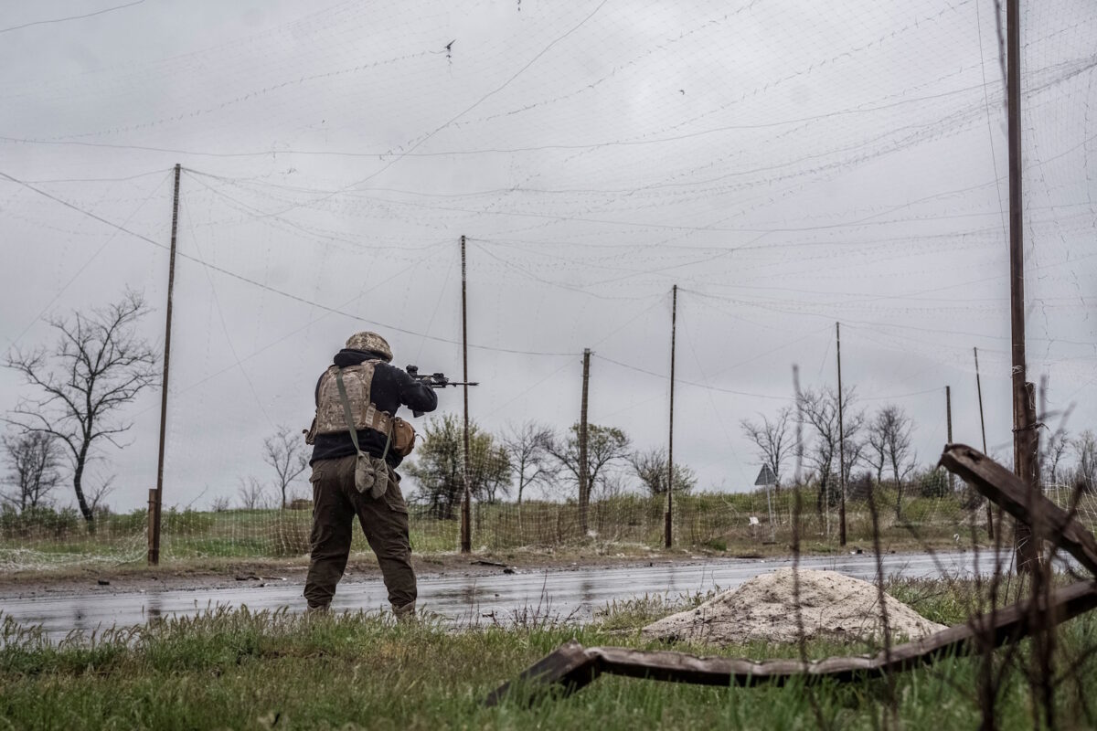 A serviceman of the 24th Separate Mechanized Brigade of the Ukrainian Armed Forces fires an assault rifle to shoot down a Russian drone during a mission to protect streets in the frontline town of Druzhkivka, amid Russia's attack on Ukraine, in Donetsk region, Ukraine April 24, 2026. REUTERS