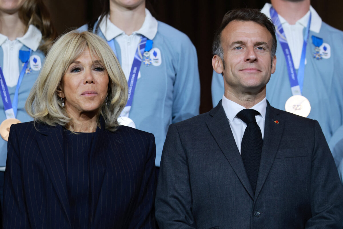 French President Emmanuel Macron and his wife Brigitte Macron pose for a group photo during a medal ceremony for French athletes who participated in the Milan-Cortina 2026 Winter Olympic Games, at the Elysee Palace in Paris, France, April 29, 2026. REUTERS/Stephanie Lecocq/Pool