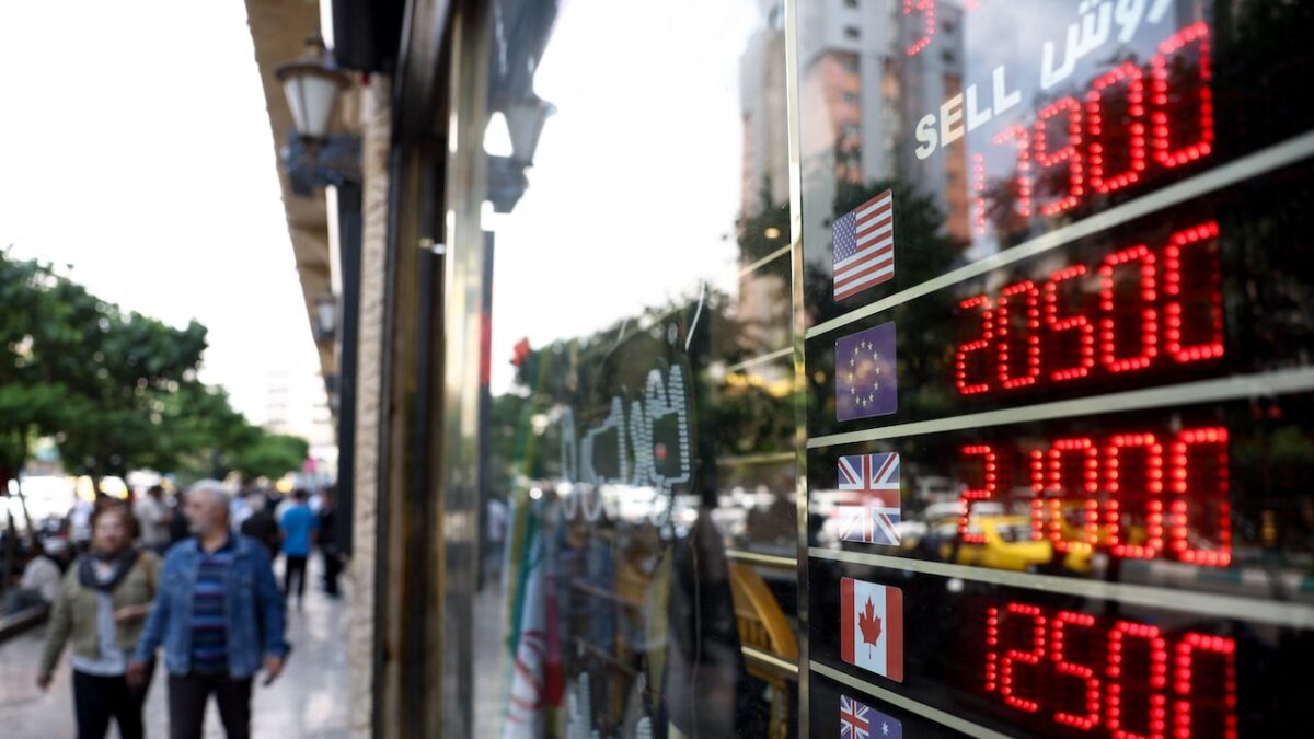 People walk near a display at a currency exchange bureau, as the value of the Iranian rial drops, in Tehran, Iran, May 2, 2026. Majid Asgaripour/WANA (West Asia News Agency) via REUTERS ATTENTION EDITORS - THIS PICTURE WAS PROVIDED BY A THIRD PARTY