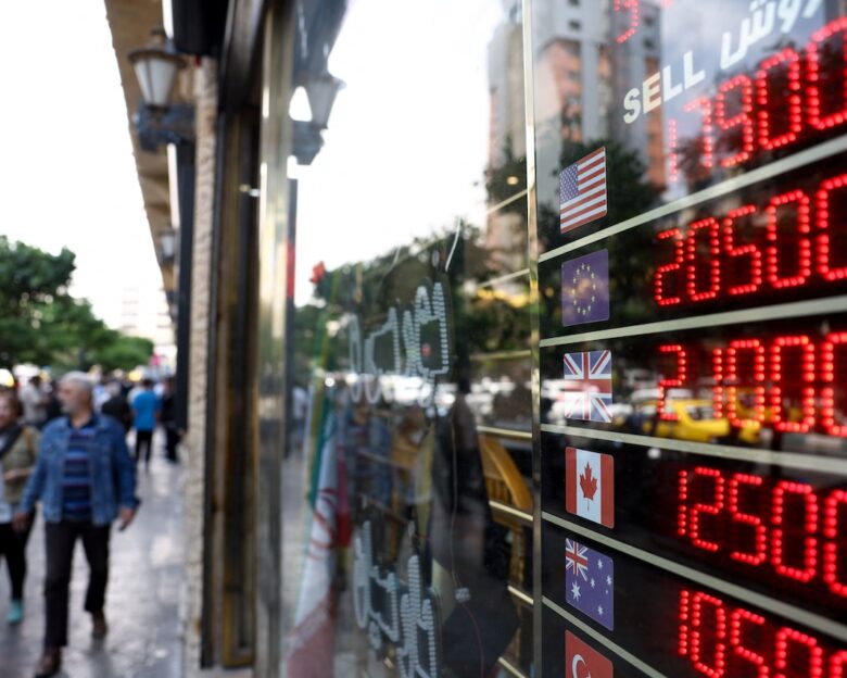 People walk near a display at a currency exchange bureau, as the value of the Iranian rial drops, in Tehran, Iran, May 2, 2026. Majid Asgaripour/WANA (West Asia News Agency) via REUTERS ATTENTION EDITORS - THIS PICTURE WAS PROVIDED BY A THIRD PARTY