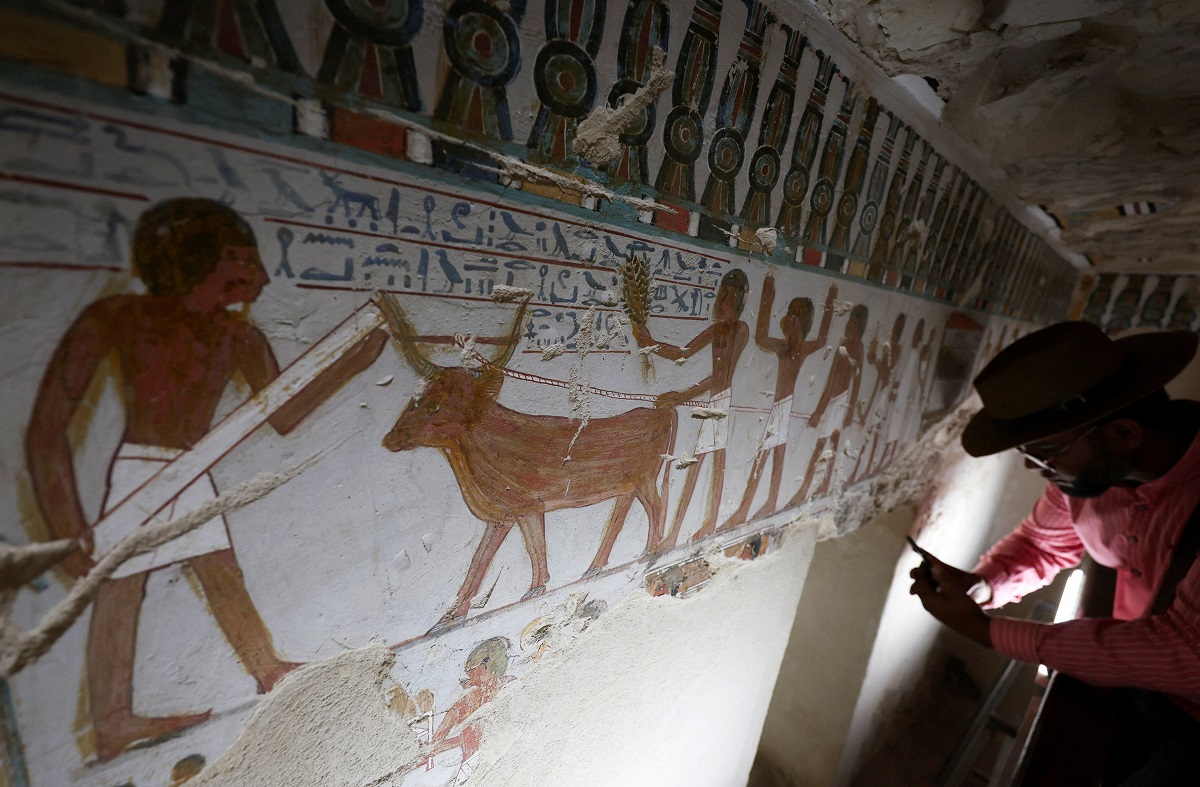 A visitor takes a picture inside the recently restored ancient "Amenhotep Rabuia" (TT416) in the El-Khokha necropolis on the west bank of the Nile in Luxor, where Egyptian authorities have announced the completion of restoration work on two 18th Dynasty tombs belonging to Amenhotep Rabuia and his son Samut, dating back to the reigns of Pharaohs Thutmose III and Thutmose IV, that contain scenes illustrating daily life, funerary practices, and religious imagery from ancient Egypt, in Egypt, May 14, 2026. REUTERS