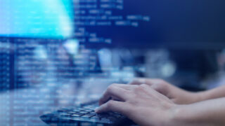 close up programmer man hand typing on keyboard at computer desktop for input coding language to software for fix bug and defect of system in operation room , technology concept