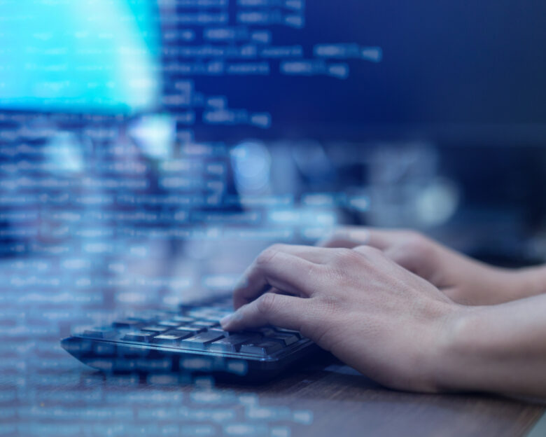 close up programmer man hand typing on keyboard at computer desktop for input coding language to software for fix bug and defect of system in operation room , technology concept