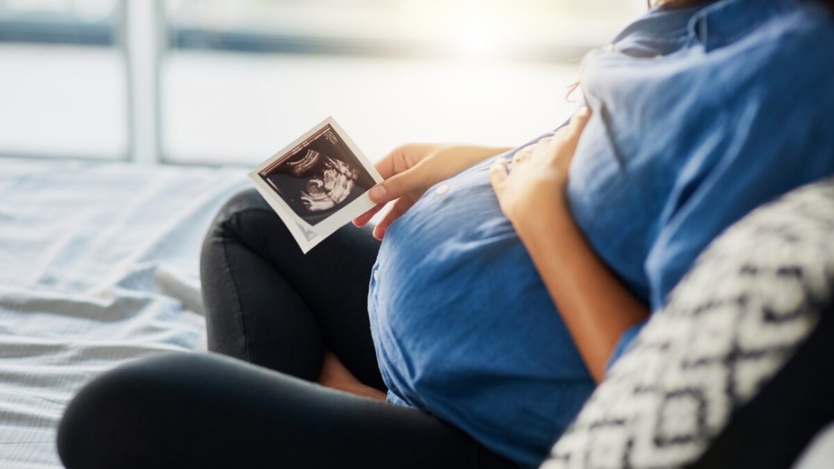 Closeup shot of an unrecognizable pregnant woman holding an ultrasound scan
