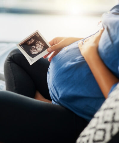 Closeup shot of an unrecognizable pregnant woman holding an ultrasound scan