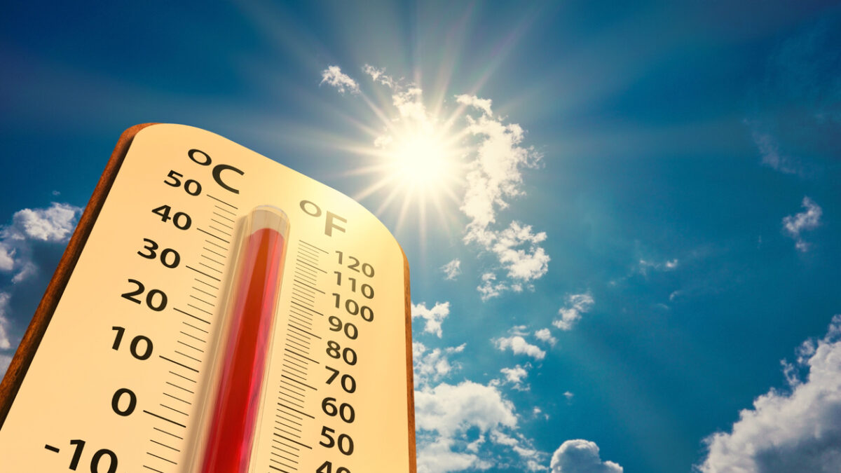 climate change, low angle view Thermometer on blue sky with sun shining in summer show increase temperature, concept global warming