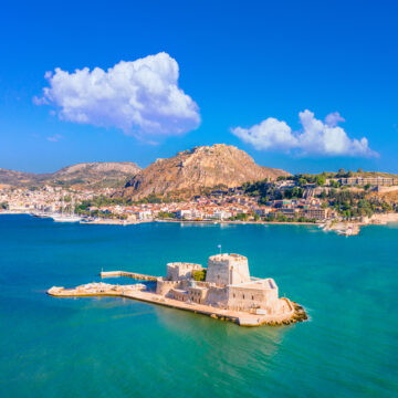 The old town of Nafplion in Greece with tiled roofs, small port, bourtzi castle, Palamidi fortress