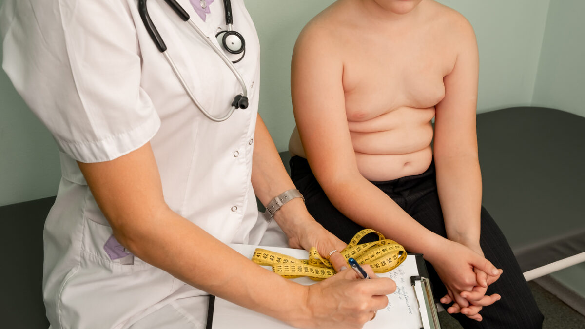 Childhood obesity problem and weight loss. Fat boy at a nutritionist appointment. Overweight boy consulting with doctor in office. Doctor examining fat boy in clinic. Doctor measuring overweight boy.