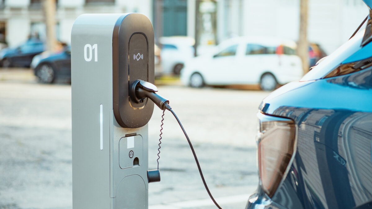 Electric cars on chargers on modern public parking