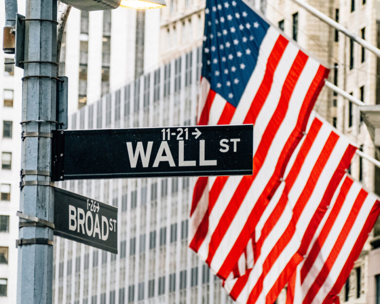 Wall street district in New York City with USA flags in the background. Famous financial district in New York City Lower Manhattan.