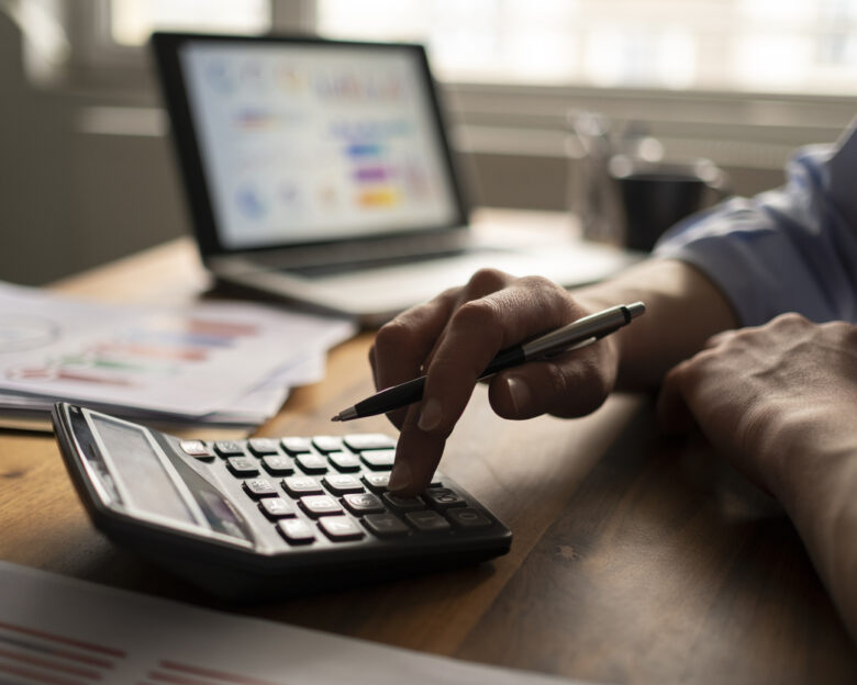 Business accounting concept, Business man using calculator with computer laptop, budget and loan paper in office.