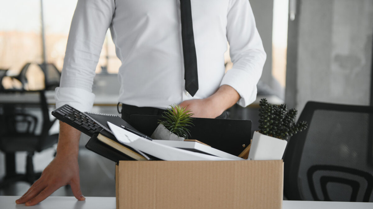 Close-up Of A Businessperson Carrying Cardboard Box During Office Meeting.