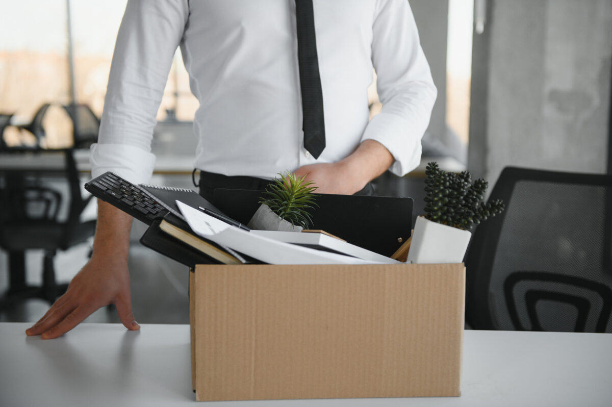 Close-up Of A Businessperson Carrying Cardboard Box During Office Meeting.