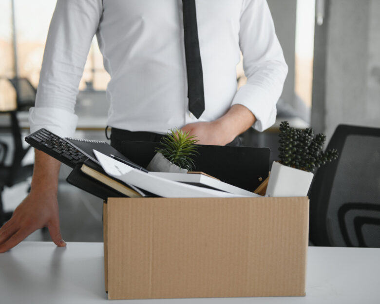 Close-up Of A Businessperson Carrying Cardboard Box During Office Meeting.