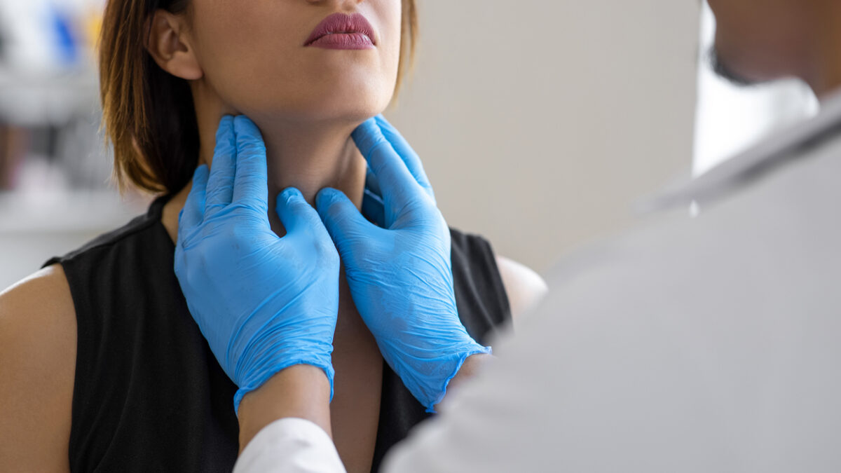 Doctor checking thyroid of a patient