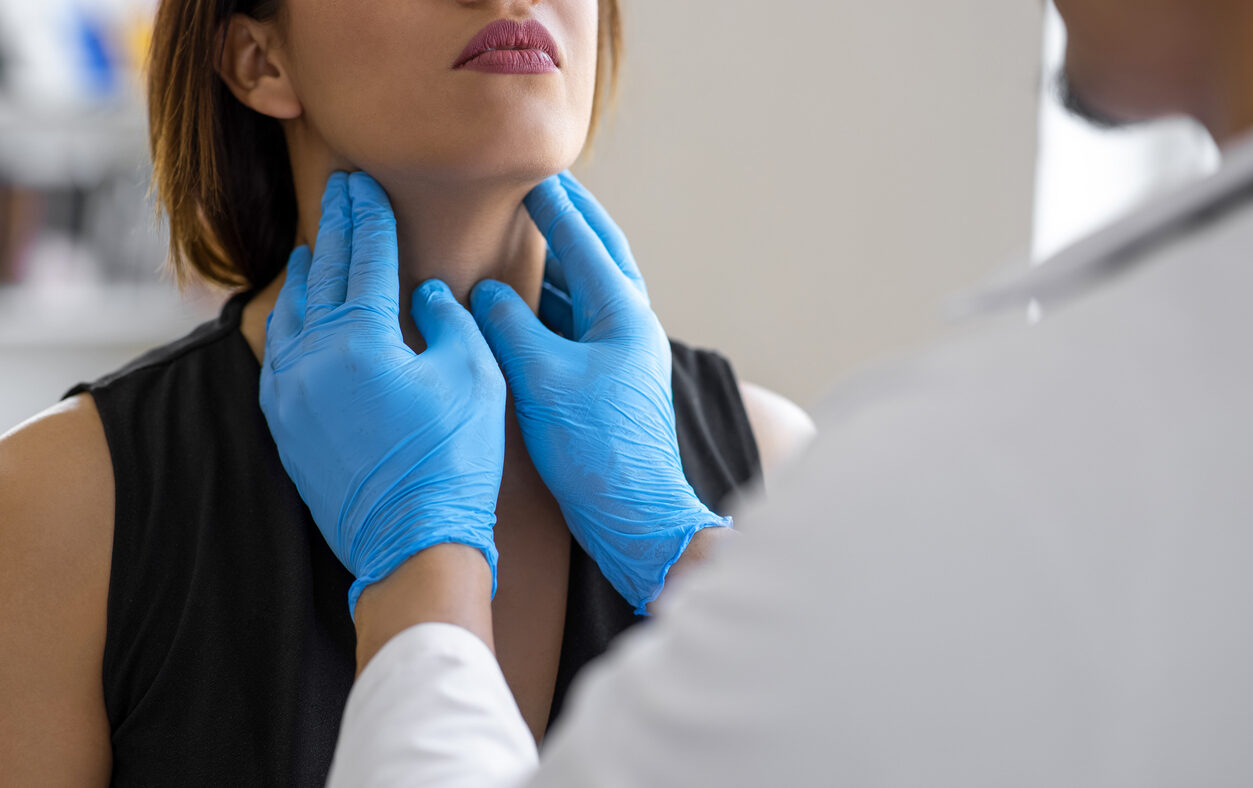 Doctor checking thyroid of a patient