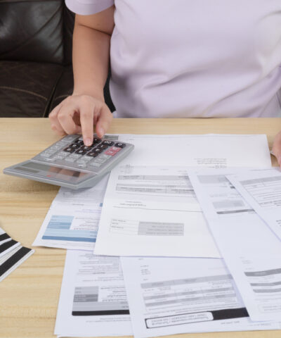 Young woman pressing the calculator for calculate the money for her dept. Asian women are stressed about payment loan problem. people with personal financial crisis concept. Debt, loan concept.