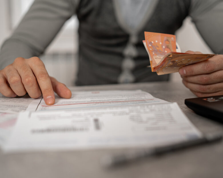 With a furrowed brow and a deep sense of anxiety, the mid-adult man works to manage his bills and debt