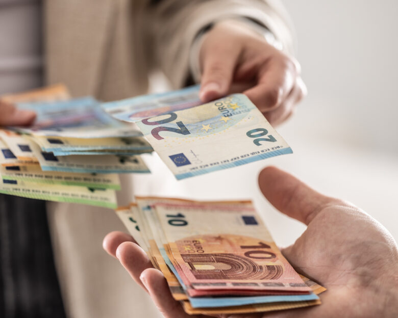 Businesswoman's hands exchanging euro banknotes, closeup shot
