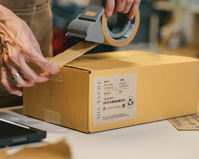 A small business warehouse worker owner packing and labeling eco friendly brown paper honeycomb wrapped with environmental Sustainability friendly paper biodegradable materials before shipping to customers,zero waster and plastic free concept