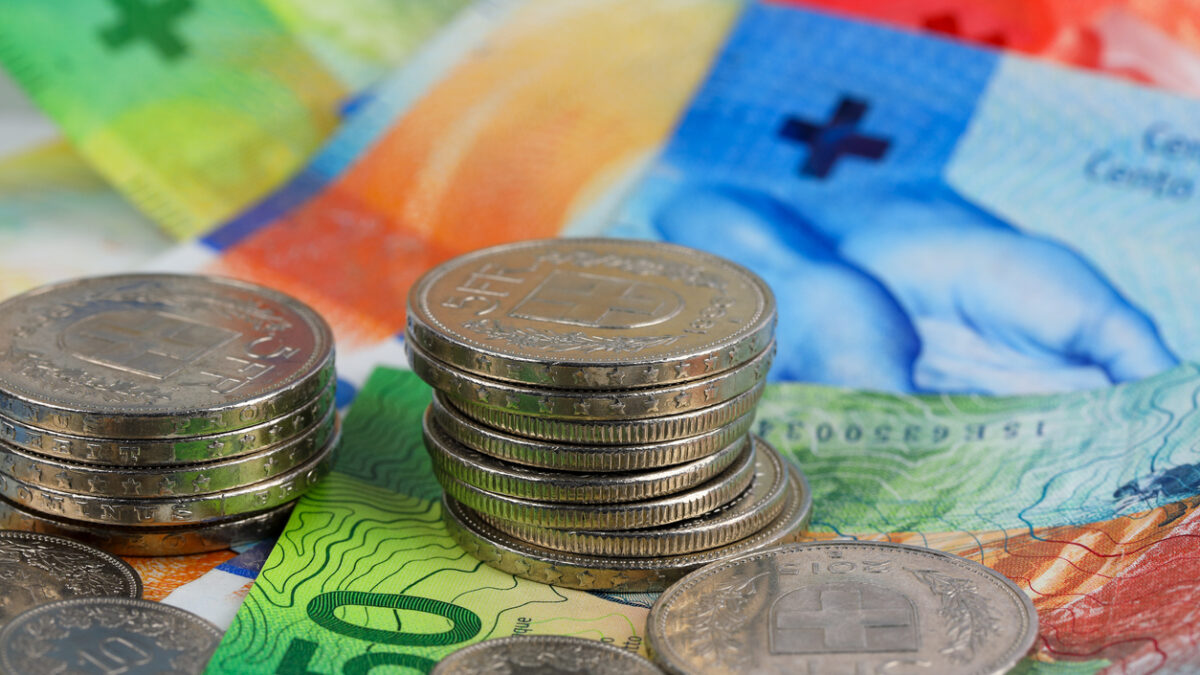 The Swiss currency, CHF, is visible. Coins are shown lying on paper money. It can be used to illustrate a wide range of financial topics.