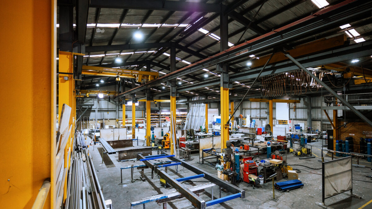 Large industrial warehouse with machinery and yellow support structures , with steel and metal processing equipment