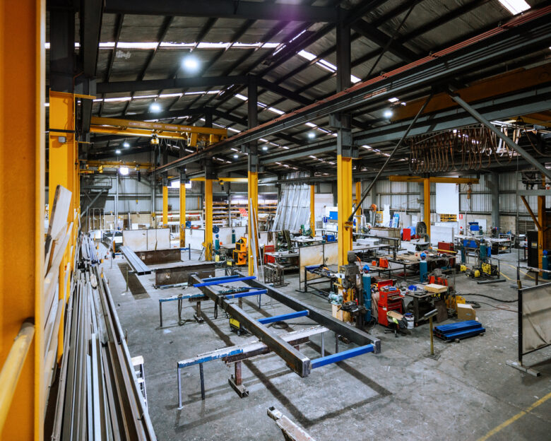 Large industrial warehouse with machinery and yellow support structures , with steel and metal processing equipment