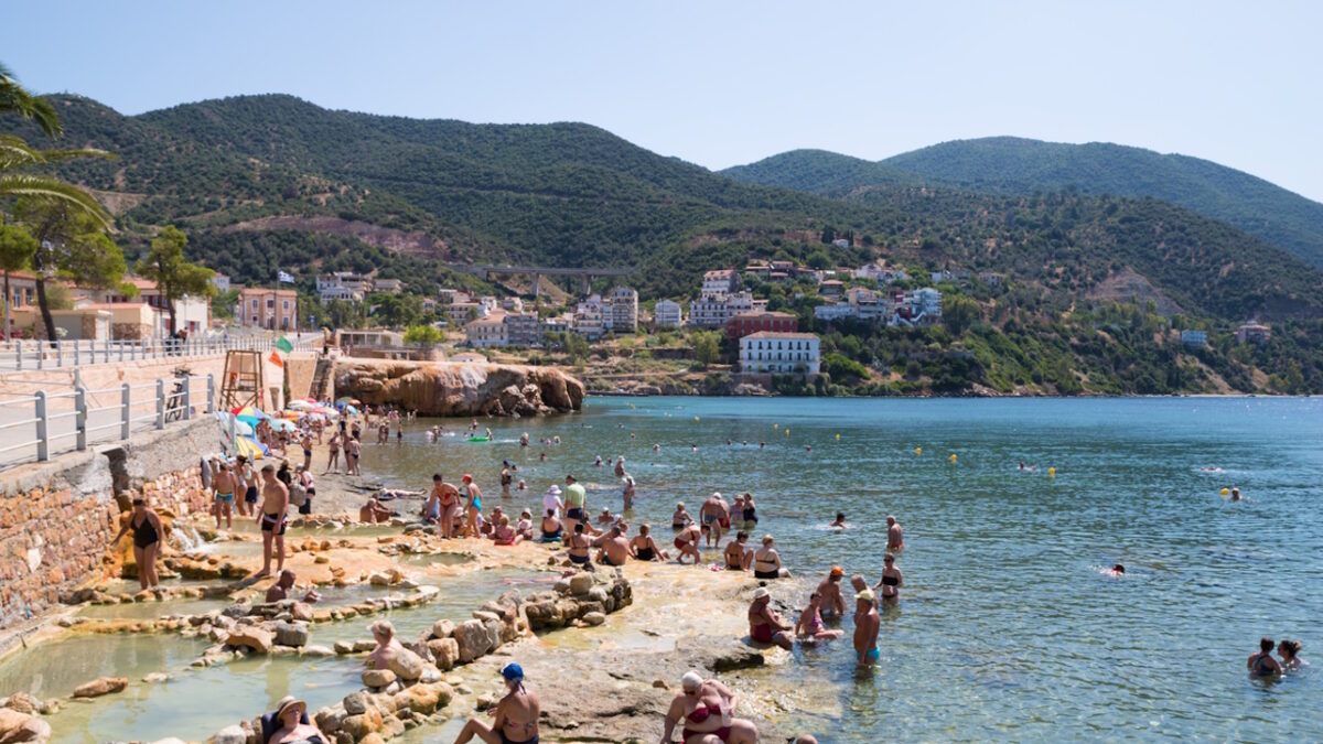 Aidipsos, Greece - The waterfront of Aidipsos, a Greek town in North Evia famous for its hot springs and spas, with lots of people enjoying the free warm water spa