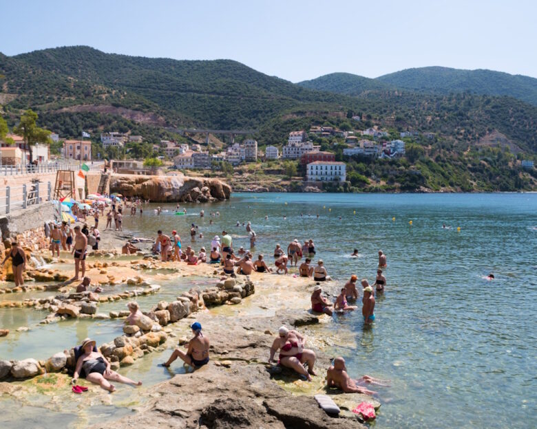 Aidipsos, Greece - The waterfront of Aidipsos, a Greek town in North Evia famous for its hot springs and spas, with lots of people enjoying the free warm water spa