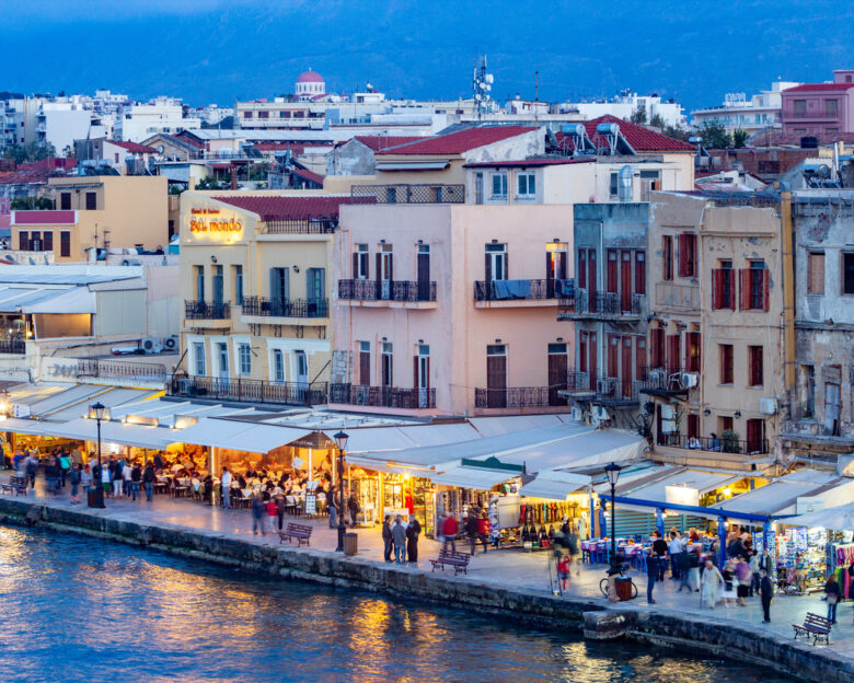 Chania Harbour on Crete, Greece. These are commercial buildings, with many people visible.