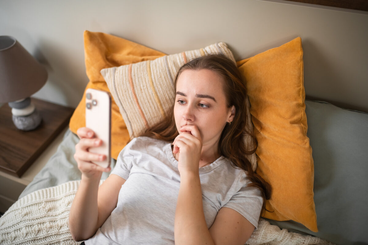 Young woman with smartphone indoors