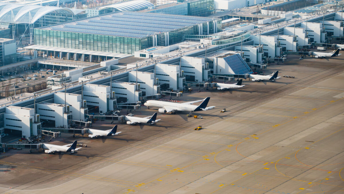 Multiple aircraft docked at terminal gates seen from above. Airport operations and boarding. Munich International Airport, Germany.