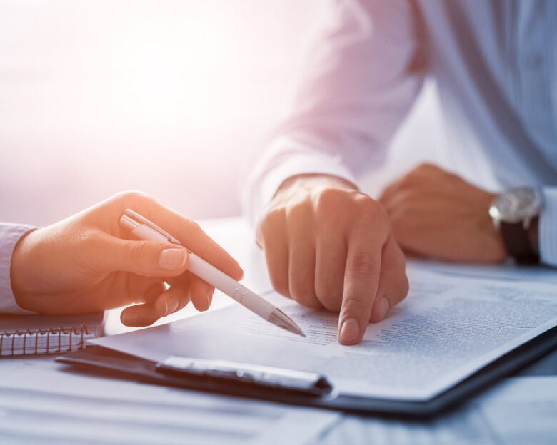 Business people negotiating a contract. Human hands working with documents at desk and signing contract.