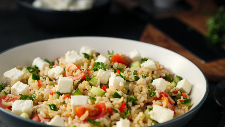 Home made freshness Healthy fluffy brown rice with chopped parsley,capers,cherry tomatoes and cucumbers and feta cubes.