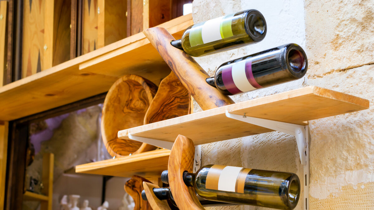 Decorative wooden holder handmade with bottles of white and red Greek wine. Unique Souvenirs from the old resort town Rethymno in Greece. Culture and Mediterranean cuisine on island Crete