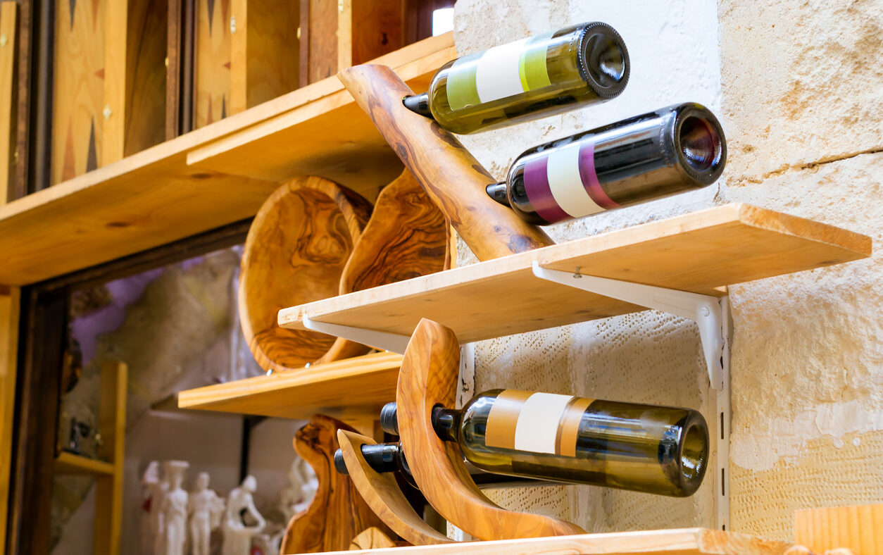 Decorative wooden holder handmade with bottles of white and red Greek wine. Unique Souvenirs from the old resort town Rethymno in Greece. Culture and Mediterranean cuisine on island Crete