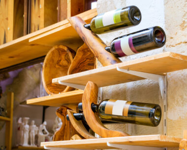 Decorative wooden holder handmade with bottles of white and red Greek wine. Unique Souvenirs from the old resort town Rethymno in Greece. Culture and Mediterranean cuisine on island Crete