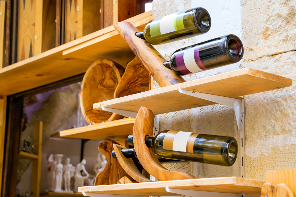 Decorative wooden holder handmade with bottles of white and red Greek wine. Unique Souvenirs from the old resort town Rethymno in Greece. Culture and Mediterranean cuisine on island Crete