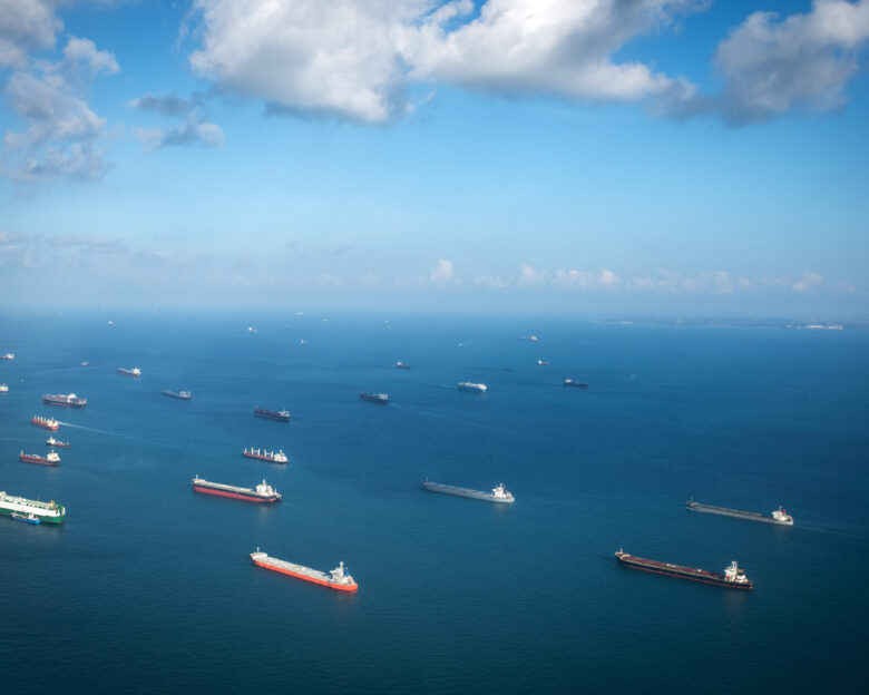 Transportation and Container ships wait on the ocean in front of the port of Singapore.