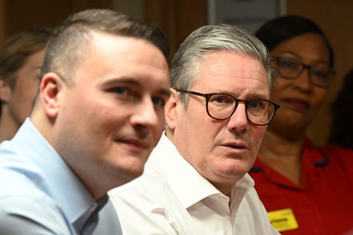 Britain's Prime Minister Keir Starmer, center, accompanied by Health Secretary Wes Streeting, left, visit a healthcare provider to deliver remarks on reducing NHS wait times, in Surrey, England, Monday, Jan. 6, 2025,
